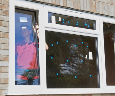 Construction Worker Installing New Windows In House